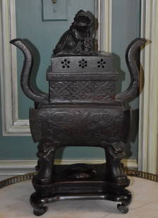 ANTIQUE ARCHAIC FORM CHINESE BRONZE CENSER: Having foo dog finial atop rectangular pierced cover, bold scroll form carrying handles the main body with allover cross hatch and archaic decoration on scroll feet with foo dog ornamented knees. Comp