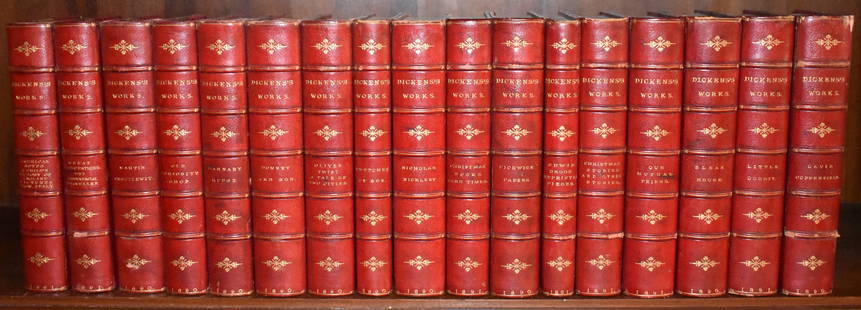 FINE BINDINGS: "DICKENS WORKS" 1891, 17 VOLUMES: Red calfskin half leather binding with tooled gilt lettering over marbled boards, London: Chapman and Hall Limited 1891. A handsome shelf of books.