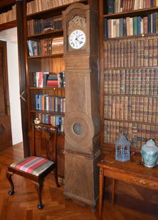 19TH CENTURY COUNTRY FRENCH TALL CASE CLOCK: Country French Comtoise tall clock, the case is pine with original grain painted finish. The movement has a porcelain dial signed . The embossed brass surround depicts a husband and wife reading the b