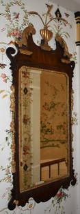 18TH CENTURY GEORGE III CHIPPENDALE LOOKING GLASS: The mahogany mirror with gilt acanthus carved scrolls centering a reeded urn form finial with wheat sheaf top, scroll sawn ears with gilt foliate sidearms, the beveled mirror with gilt carved surround