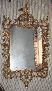 FINE ANTIQUE CHIPPENDALE STYLE GILT ROCOCO MIRROR: The Chippendale style gilt carved mirror with acanthus form finial, central basket of flowers crest with a pierced carved acanthus and floral scroll formed frame and shaped rectangular mirror plate. H