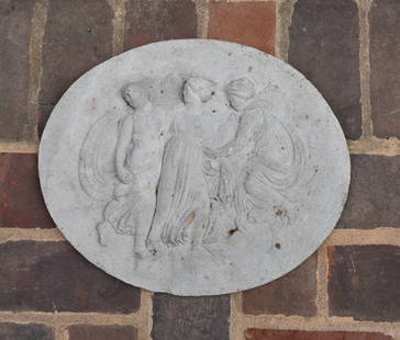 CLASSICAL CAST PORTLAND STONE PLACQUE: The cast stone placque of oval format featuring three raised Classical figures. Height 13" Width 16"