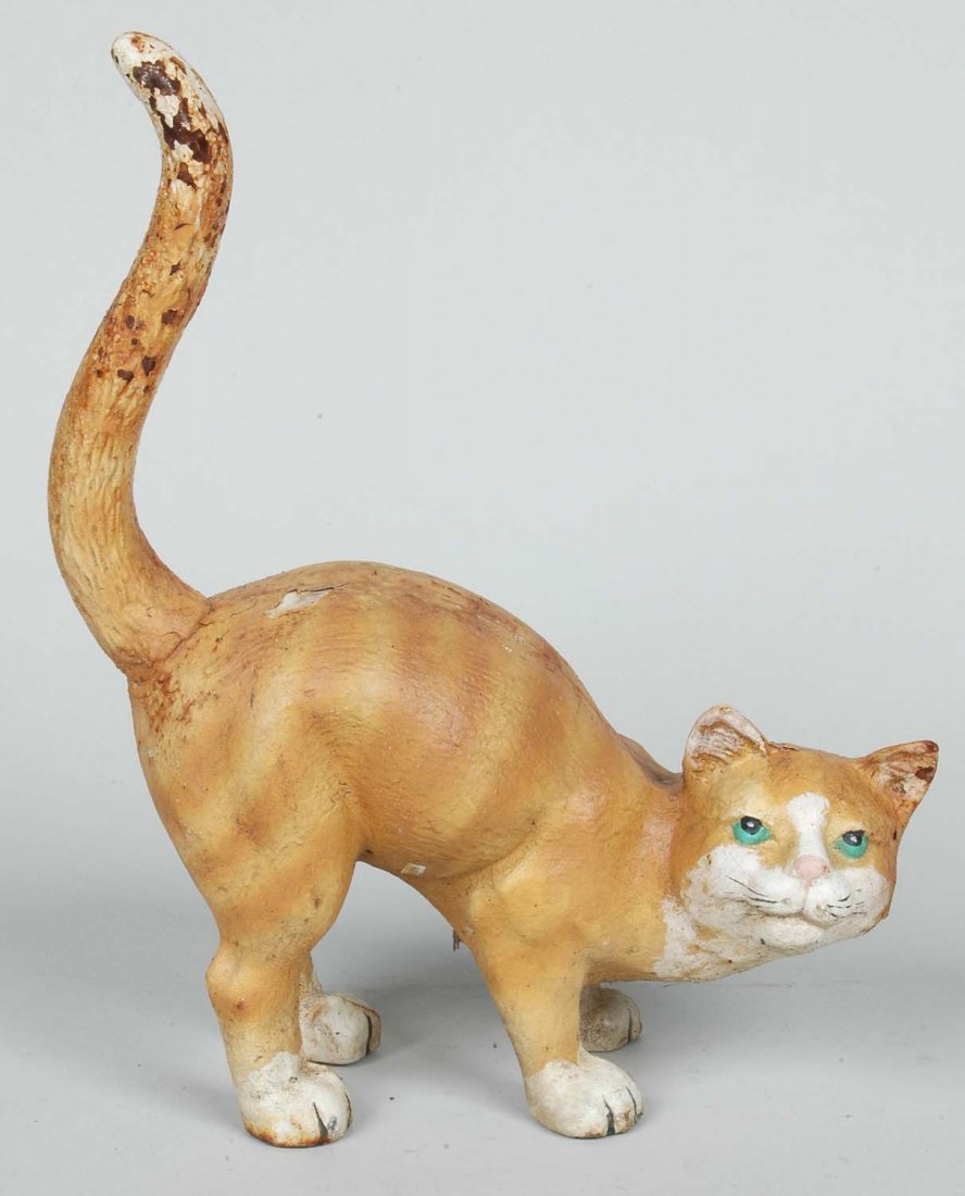 PAINT DECORATED CAST IRON CAT DOORSTOP: The yellow crouching cat with raised tail. Ht.