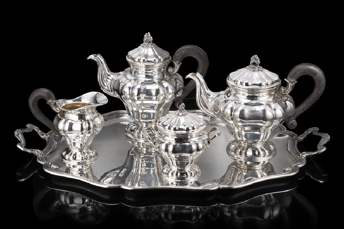 A silver set comprising a coffee pot, a tea pot, a: A silver set comprising a coffee pot, a tea pot, a sugar bowl and a milk jug. Milan, 1930s-40s. Fascio hallmarks (h max cm 21) and a silver tray (cm 62,5x41) (total gross weight gr 4300 ca) (minor def