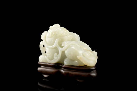 A celadon jade model of a qilin with lotus buds, the: A celadon jade model of a qilin with lotus buds, the stone with some minor russet inclusionsChina, 19th century(l.10 cm.)Qilin con ramo di loto in giada celadon con qualche inclusione russetCina, seco