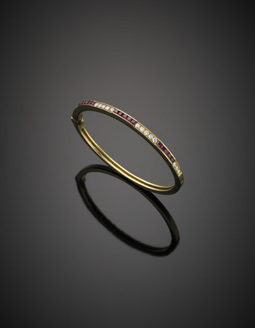 Round diamond, in all ct. 0.80 circa and carré ruby, in: Round diamond, in all ct. 0.80 circa and carré ruby, in all ct. 1.05 circa yellow gold bangle, g 20.42, diam. cm 5.80.Bracciale rigido in oro giallo rifinito con diamanti rotondi per complessivi ct.