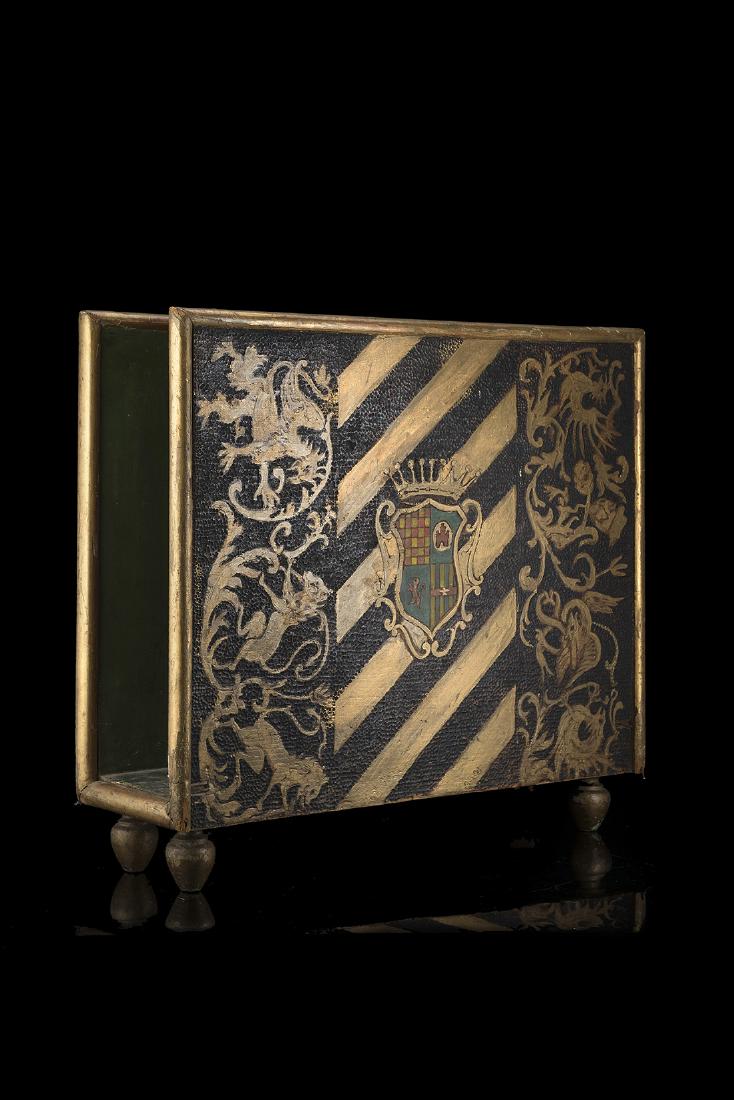 A polychrome giltwood magazine rack with the coat of: A polychrome giltwood magazine rack with the coat of arms of Giovio Della Torre Rezzonico Lattuada and Rossi Martini Giovio families (cm 50x43) (defects) IT Portariviste in legno dorato con pannelli d