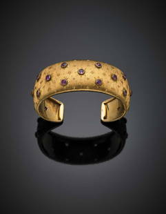 BUCCELLATI Yellow chiselled gold and ruby bangle, in: BUCCELLATI Yellow chiselled gold and ruby bangle, in all ct. circa g 28.37, h cm 2.2, diam. cm 5.5 circa. Signed Buccellati. IT BUCCELLATI Bracciale rigido alla schiava in oro giallo cesellato e rubin