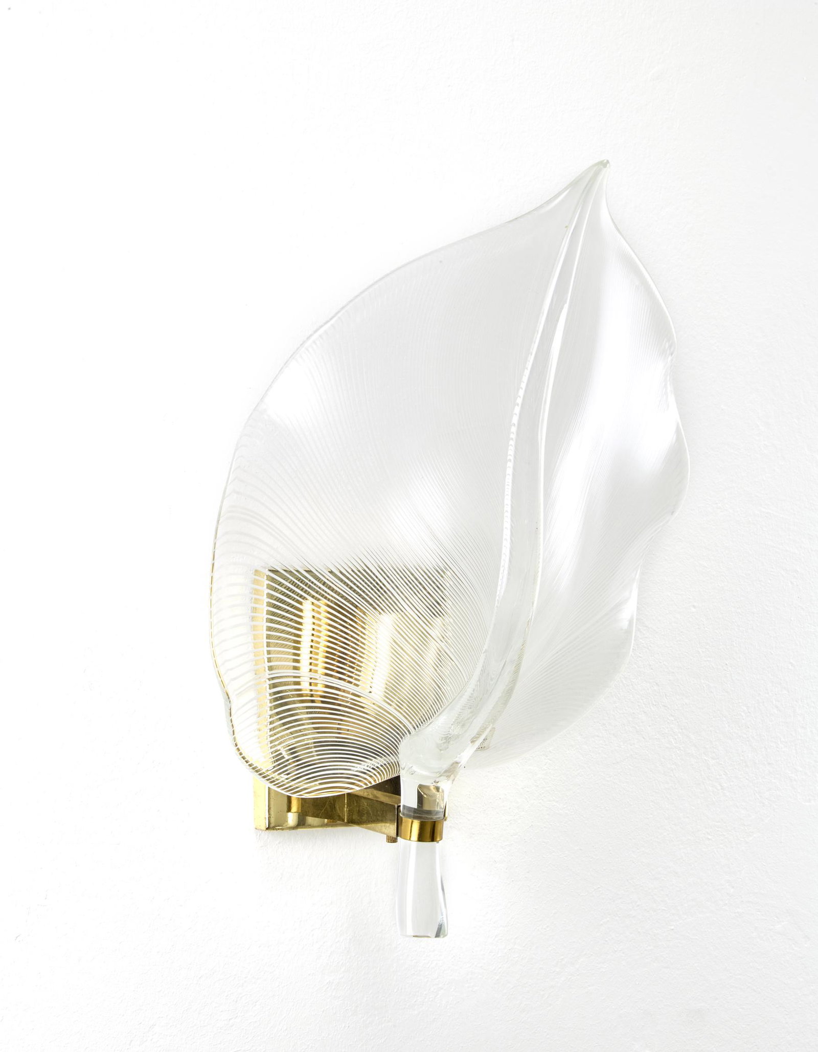 Franco Luce Wall lamp. Murano, 1970s. Brass structure: Franco Luce Wall lamp. Murano, 1970s. Brass structure and leaf-shaped diffuser in transparent colorless and milky half-filigree blown glass. With adhesive label. (h 43.5 cm.) IT Lampada da parete. Mur