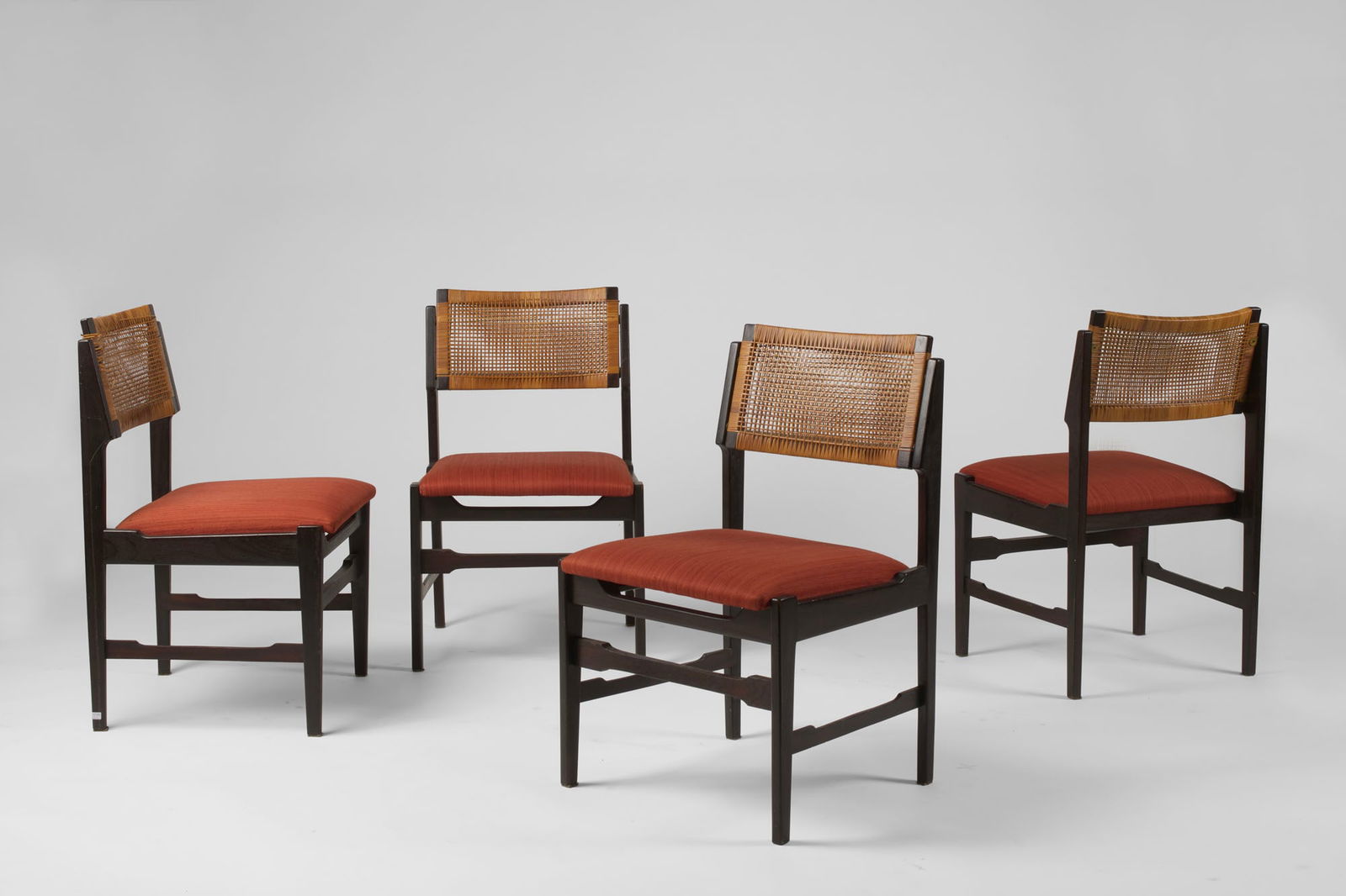 Topform (Attributed) Four solid teak chairs with padded seats upholstered in red fabric and wicker: Topform (Attributed) Four solid teak chairs with padded seats upholstered in red fabric and wicker backrests. Italy, 1960s. (defects) IT (Attribuito) Quattro sedie in teak massello con seduta imbottit
