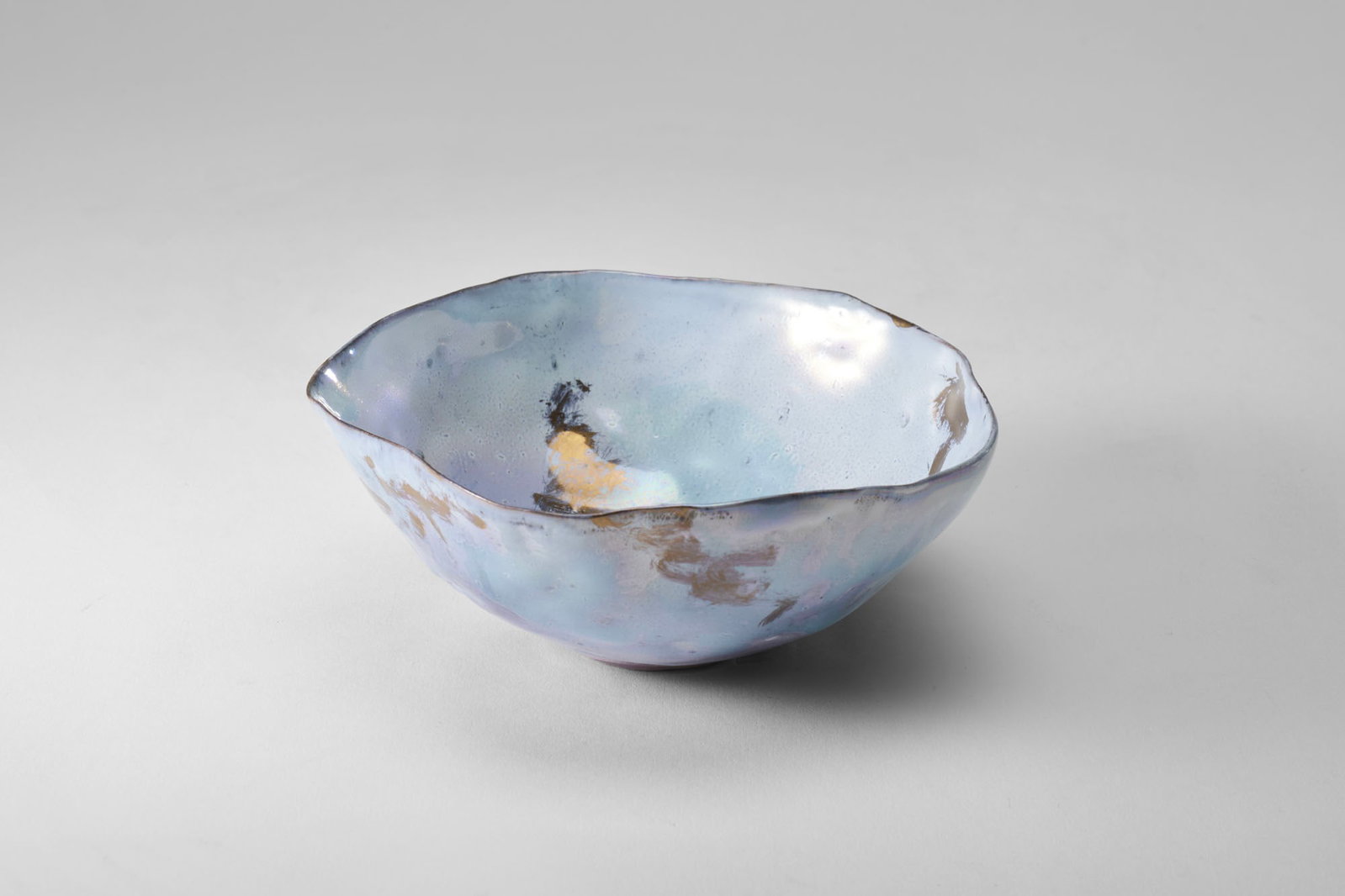 Fausto Melotti (Rovereto 1901 - Milano 1986) Small bowl. 1955ca. Polychrome glazed ceramic in shades: Fausto Melotti (Rovereto 1901 - Milano 1986) Small bowl. 1955ca. Polychrome glazed ceramic in shades of light blue, white, pink, gold, and metallic luster. Signed on the bottom with seven dots. (d 13 
