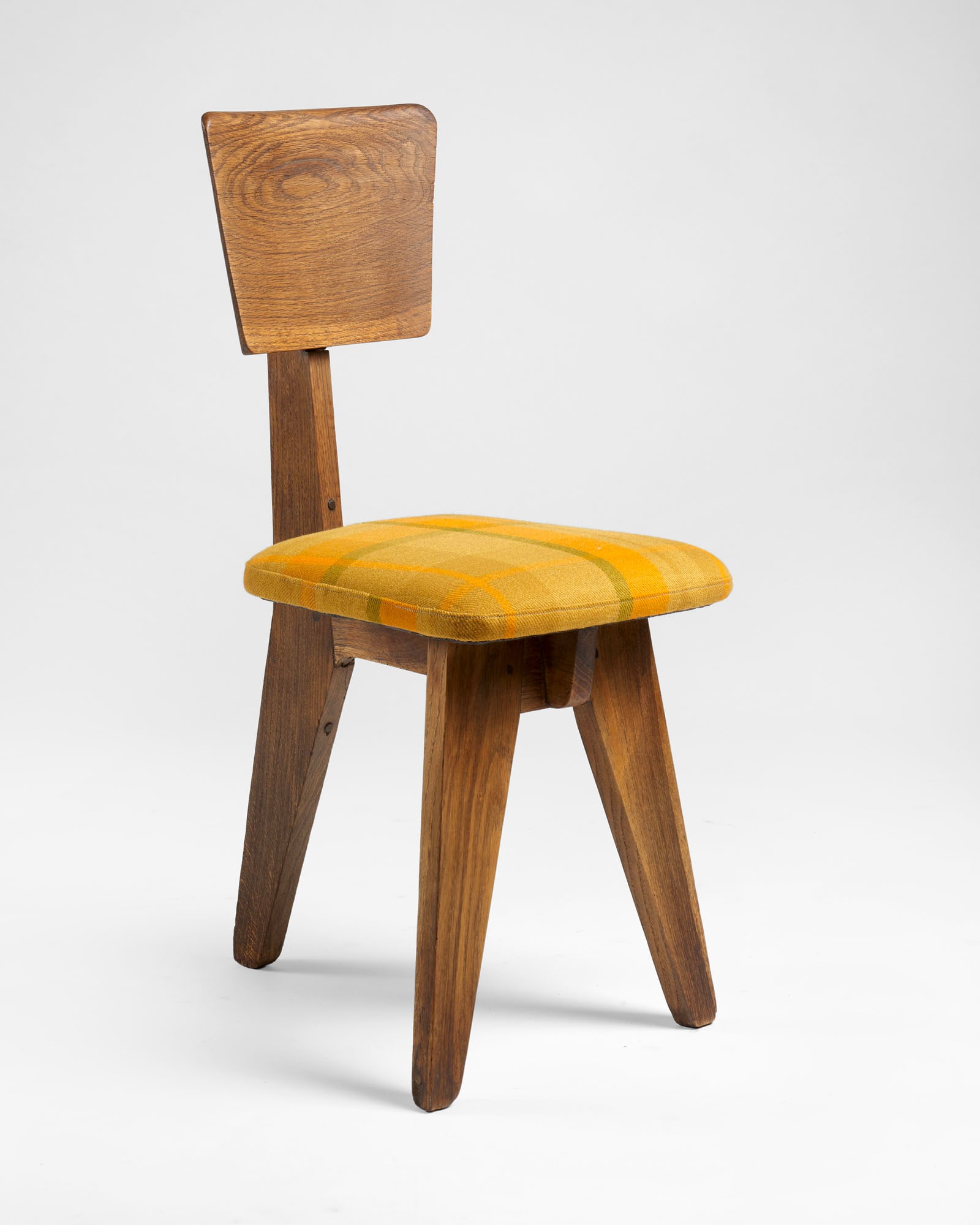 Three-legged chair. Aosta Valley, 1940s. Oak wood with padded seat covered in yellow and green: Three-legged chair. Aosta Valley, 1940s. Oak wood with padded seat covered in yellow and green checked fabric. (slight defects) IT Sedia a tre gambe. Valle d'Aosta, anni '40. Legno di rovere con sedut