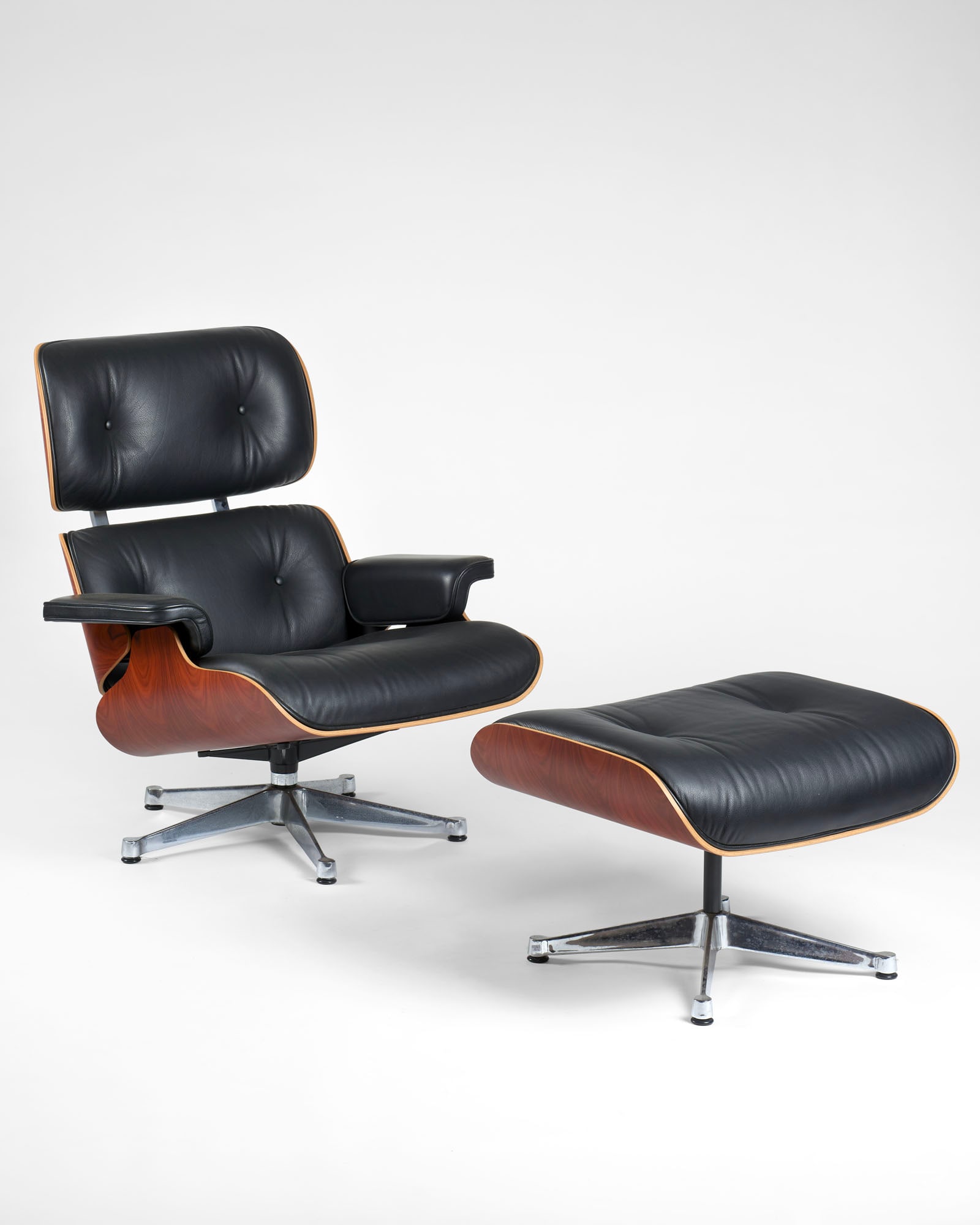 Charles Eames (1907-1978) e Ray Eames (1912-1988) Armchair and footrest. Produced by Vitra, Basel,: Charles Eames (1907-1978) e Ray Eames (1912-1988) Armchair and footrest. Produced by Vitra, Basel, disegno del 1956, produzione recente. Plywood shells, cushions upholstered in dark brown leather, bas