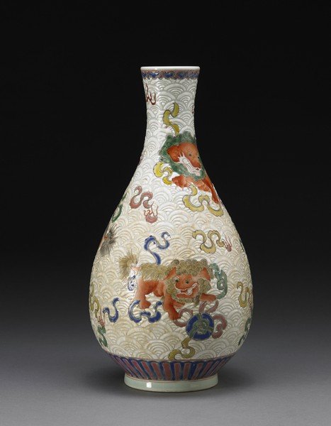 A polychrome bottle vase, decorated with Buddhist lions: A polychrome bottle vase, decorated with Buddhist lions with brocade balls against a white ground with geometric motifs, with apocryphal Kangxi mark to the base China, 20th century (h cm 30)