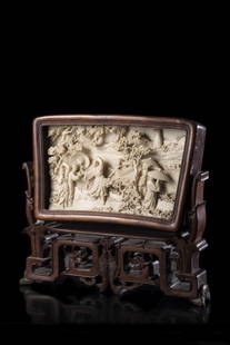 An ivory rectangular plaque, carved with figures: An ivory rectangular plaque, carved with figures amongst a river shore, inset in a pierced and carved frame and stand. China, early 20th century (l. max. 22.5 cm.) THIS LOT CANNOT BE SOLD AND SHIPPED