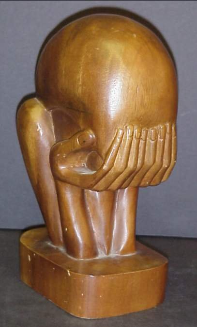 Wood carved sculpture of a figure with head in h