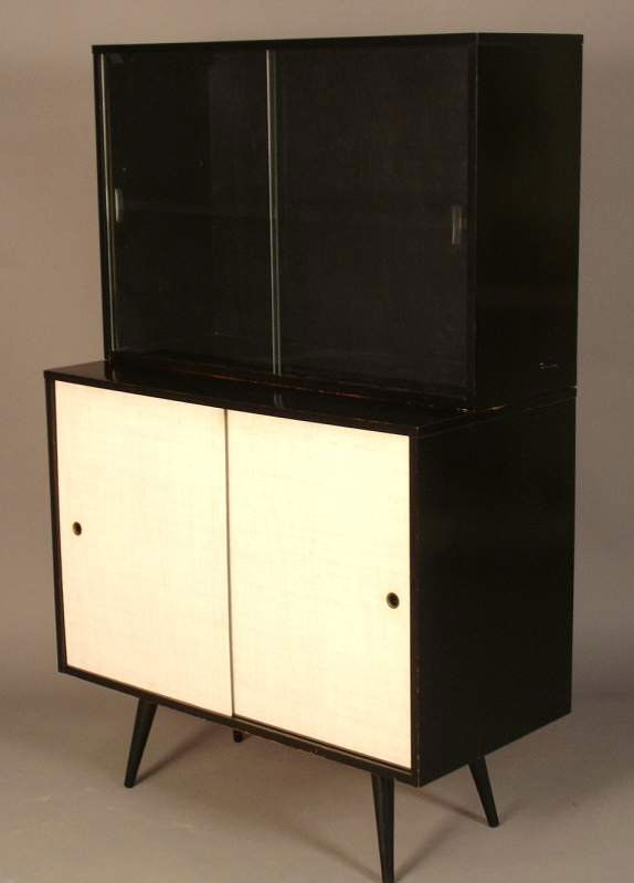 Paul McCobb / Winchendon Planner Group china cabi: Paul McCobb / Winchendon Planner Group china cabinet, black enamel finish, floating top with sliding glass doors and adjustable shelf, base has linen covered doors that conceal an adjustable shelf, ma