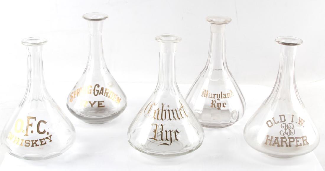 1890S SALOON BACK LIQUOR BOTTLES WHISKEY & RYE: Five late 19th Century hand-crafted saloon back of the bar liquor bottles. Each has cut glass inset gilt lettering labels. Labels include "Spring Garden Rye," "Old I.W. BB Harper," "O.F.C Whiskey," "C