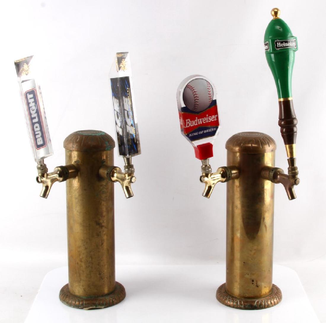 2 PIECE LOT OF VINTAGE 2 LINE BRASS BEER TAPS: Taps stand 14" tall with out handles( handle sizes vary) 4" diameter opening at the bottom. First tap has a Bud Light & Bud Ice handles. 2nd has Heineken and Budweiser handles.