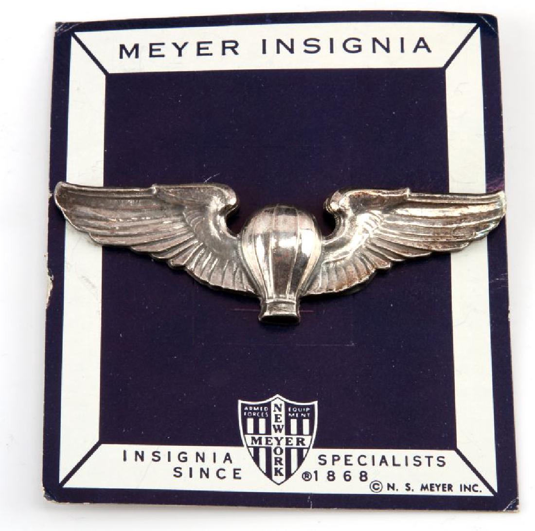 WWII USAAF ARMY AIR CORPS BALLOON PILOT WINGS: A WWII United States Army Air Force (USAAF) Balloon Pilot Wing Badge measuring 3-3/16 inches wide by 1 inches tall. The reverse of the badge has a thin, horizontal, 180-degree lie, pin back and the ma