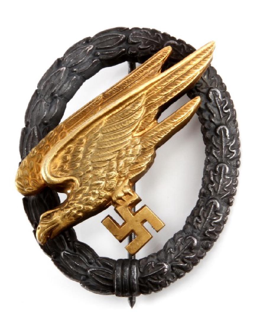 WWII GERMAN LUFTWAFFE FALLSCHIRMJAGER JUMP BADGE: A WWII German Luftwaffe Paratrooper (Fallschirmjäger) jump badge measuring 2-1/8 inches tall by 1-5/8 inches wide. The reverse of the two piece nickel domed riveted badge has a thin vertical, T-bar s