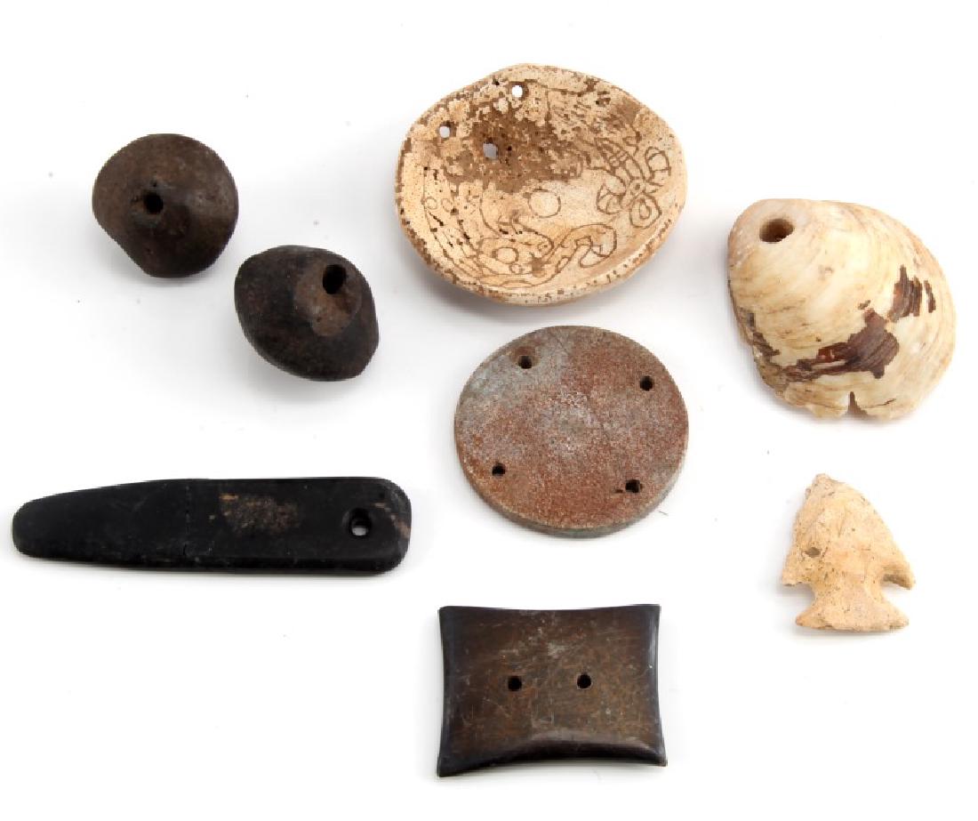NATIVE AMERICAN GORGETS SHELLS BEADS AND POINT: Lot of Native American artifacts. Lot includes a point, two beads, a two-holed gorget, a one holed gorget, a holed shell, a four holed gorget, and an incised whelk gorget.