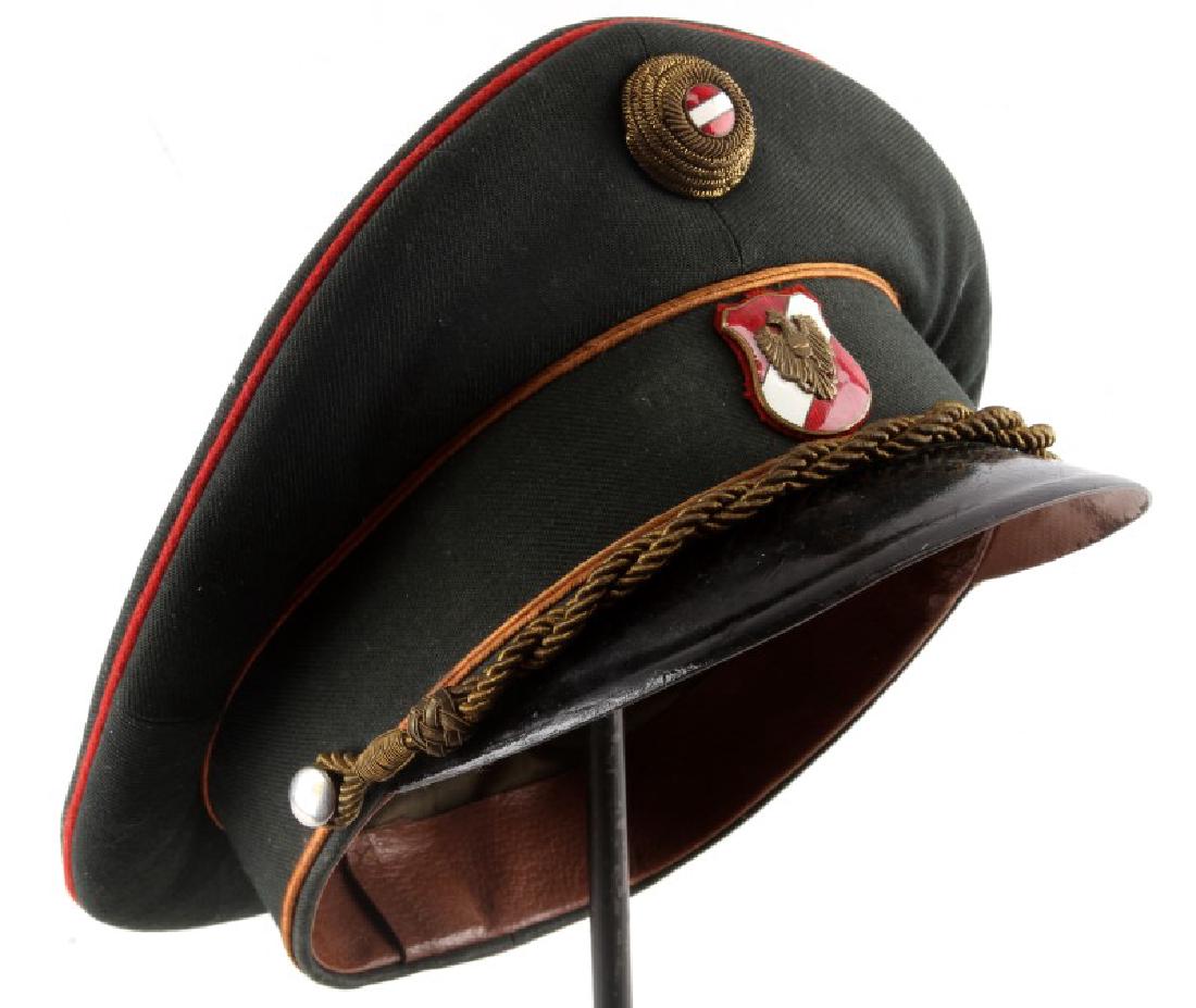 AUSTRIAN POST WAR BORDER POLICE SERVICE CAP: Austrian post war service cap for border police. Features the Austrian crest in red and white enamel. Eagle is holding the communist hammer and Russian occupation sickle. Above is a roundel made of go