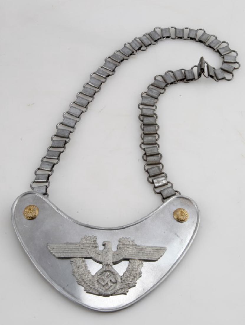GERMAN 3RD REICH WAFFEN SS POLICE GORGET W CHAIN: German Third Reich period Waffen SS police gorget with chain. Manufacturer stamp on back - "R.Z.M. M34/2". Tin (?) construction with adornments. Piece is 6 1/2"x3", total length is 16" with chain. Una