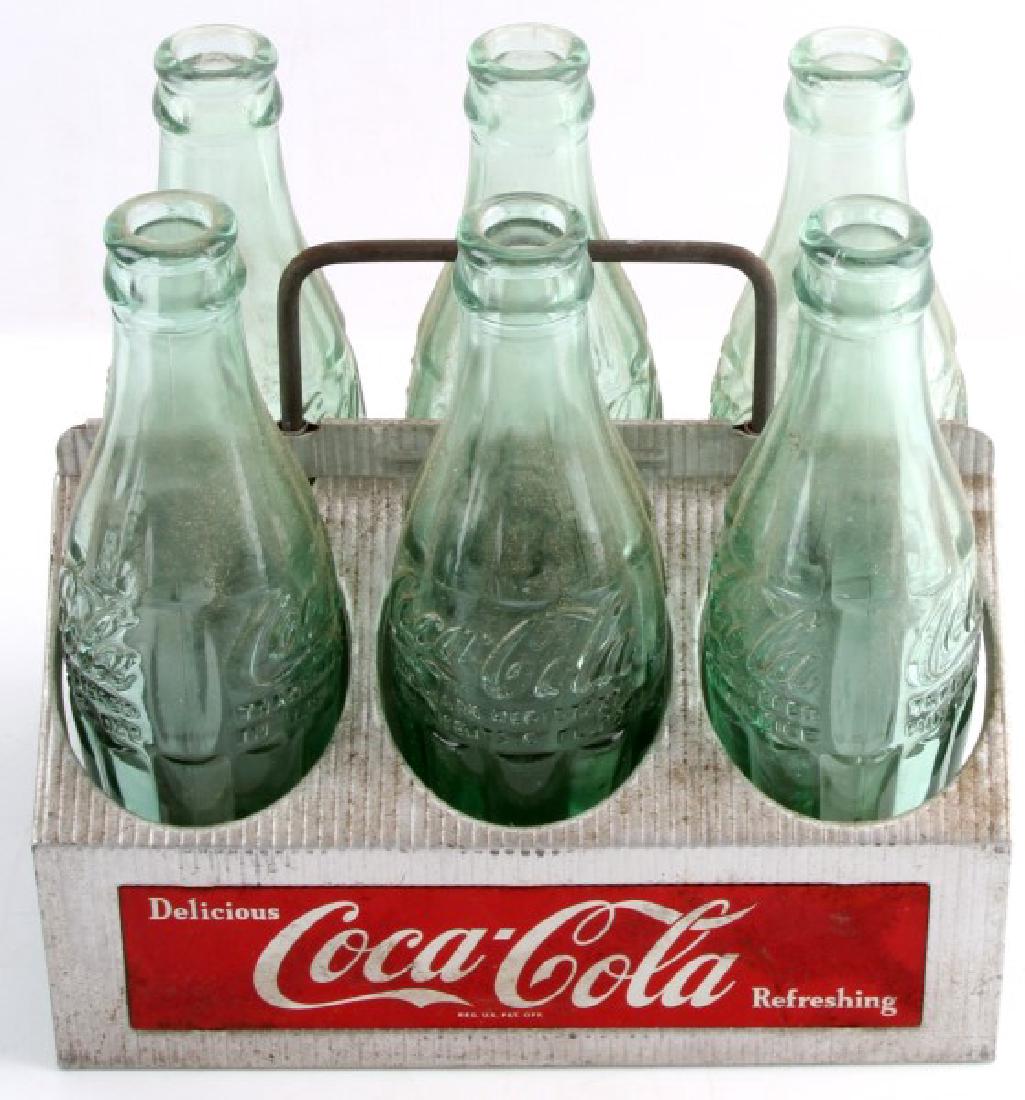 ALUMINUM COCA COLA 6 PACK CARRIER & EMPTY BOTTLES: Vintage aluminum Coca Cola 6-pack carrier comes filled with 6 empty vintage Coke bottles. All items show little to no wear and are in very good condition.