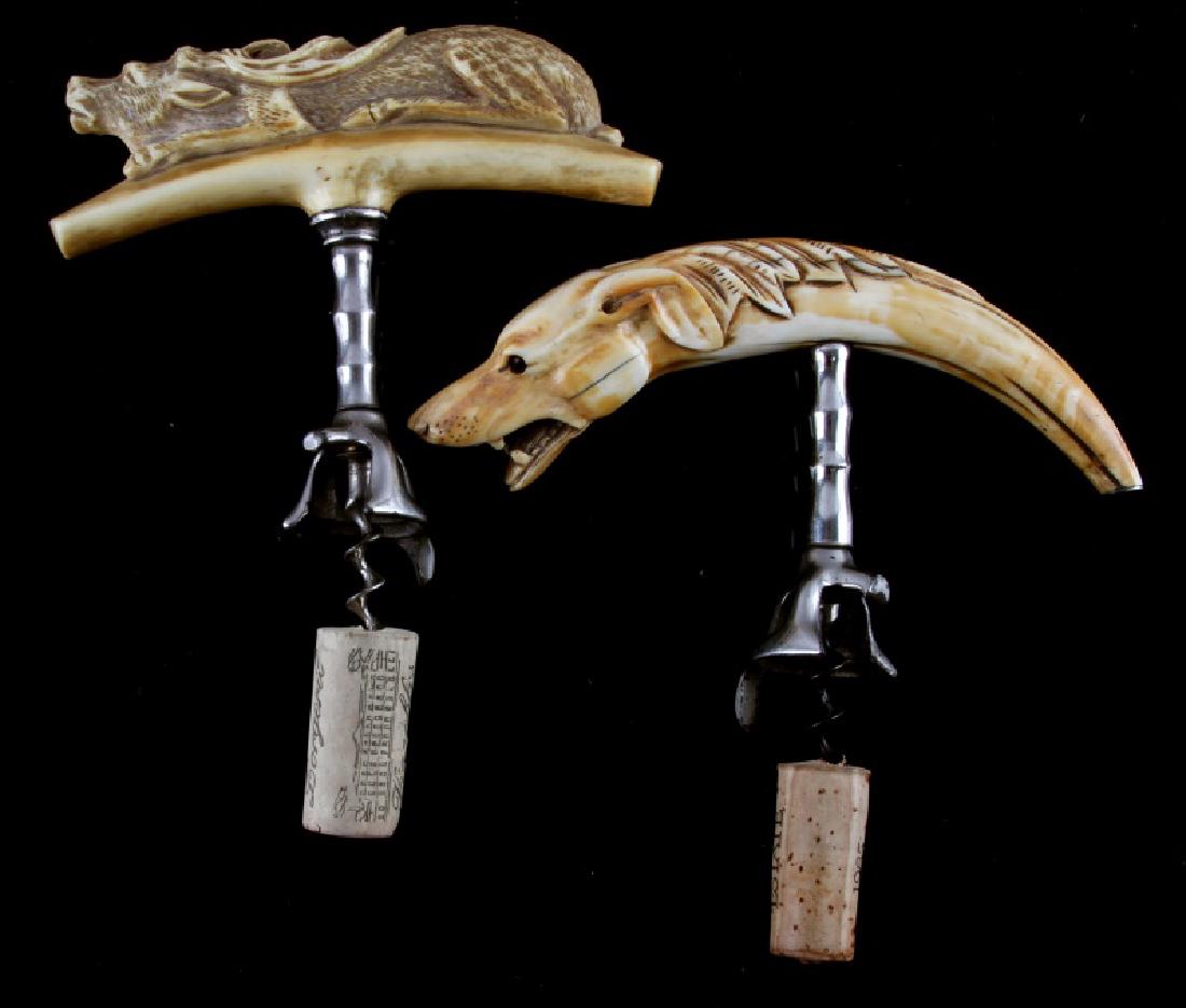 LOT OF 2 CARVED ANTIQUE BOAR TUSK CORKSCREWS: One carved boar tusk with snarling dog head and glass eyes. Metal end piece. Measures approximately 8" on a curve, and measures approximately 5" from bottom of screw to top of the handle. Weighs 188 g