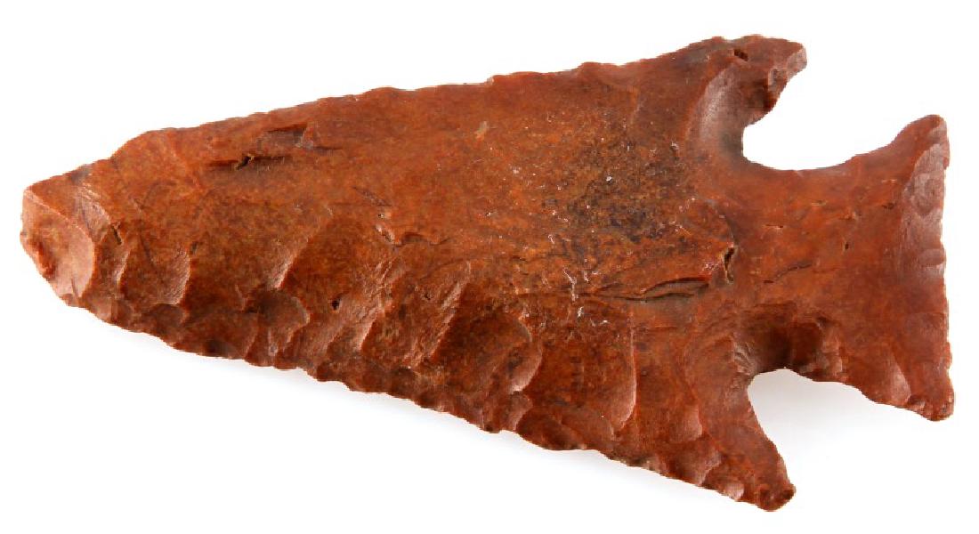 ARCHAIC LOST LAKE KENTUCKY ARROWHEAD POINT RED: Fine red Lost Lake with broad and parallel flaking, ground base, and worn patina to sight and touch. Measures 6.7cm X 3.8cm. Very good condition. COA included.