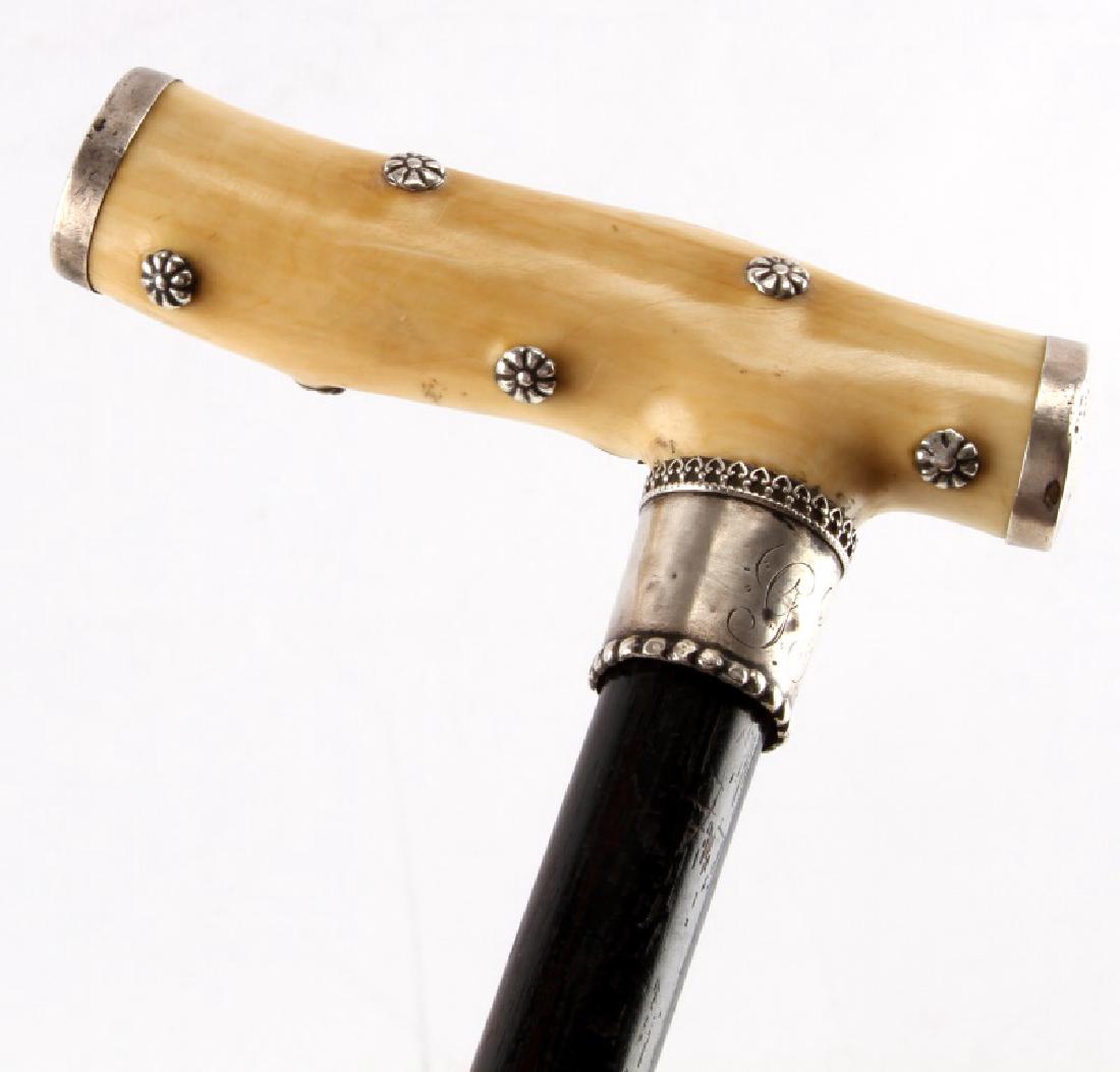 ANTIQUE STERLING SILVER BONE HANDLE WALKING STICK: Antique Sterling Silver Bone handle walking stick, measuring 30'' in total length from tip of handle to end of farrell. With an engraving on the sterling silver locket which reads "G H W" above a stam