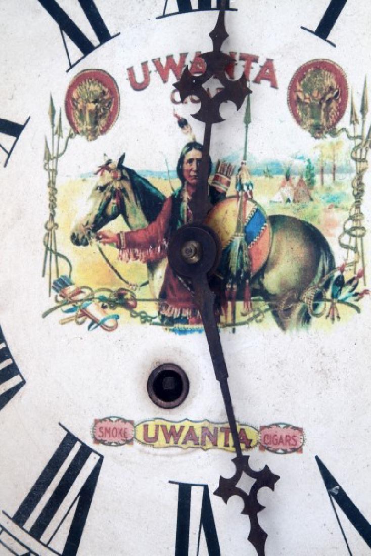 ANTIQUE INGRAHAM REGULATOR UWANTA WALL CLOCK: Face reads: "UWANTA CIGAR". Measures 22 1/2" long, by 15" across. With the key. The back has a faded label that reads, "THE E INGRAHAM CO". Untested and appears to be in good condition.
