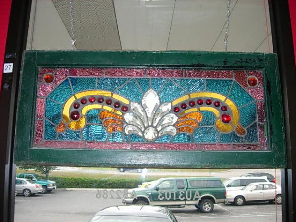 ANTIQUE STAINED GLASS JEWELED TRANSOM CINCINATTI : Stunning antique handmade stained glass transom from an Historic house in Cincinnati. Bright colors and beveled clear center piece. Size 16"x35 1/2" including the about 2" wide frame. Around 90 pieces