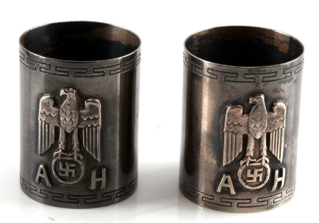 ADOLF HITLER FORMAL PATTERN NAPKIN RINGS 800 SILVE: Two Adolf Hitler silver napkin rings. Nazi eagle and initials in relief. Crudely marked "E O 800" with a symbol after. Tests for silver. Measures 2 inches in height and 1.5 inches in diameter. Dark pa