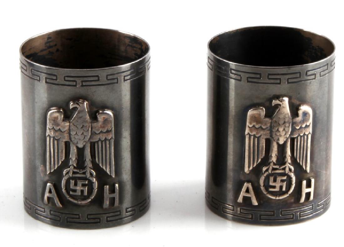 2 ADOLF HITLER FORMAL NAPKIN RINGS IN 800 SILVER: Two Hitler napkin rings with design in relief. Marked 800 silver along with symbols. Measures 2 inches tall and 1.5 inch diameter. Dark patina. Very good condition.