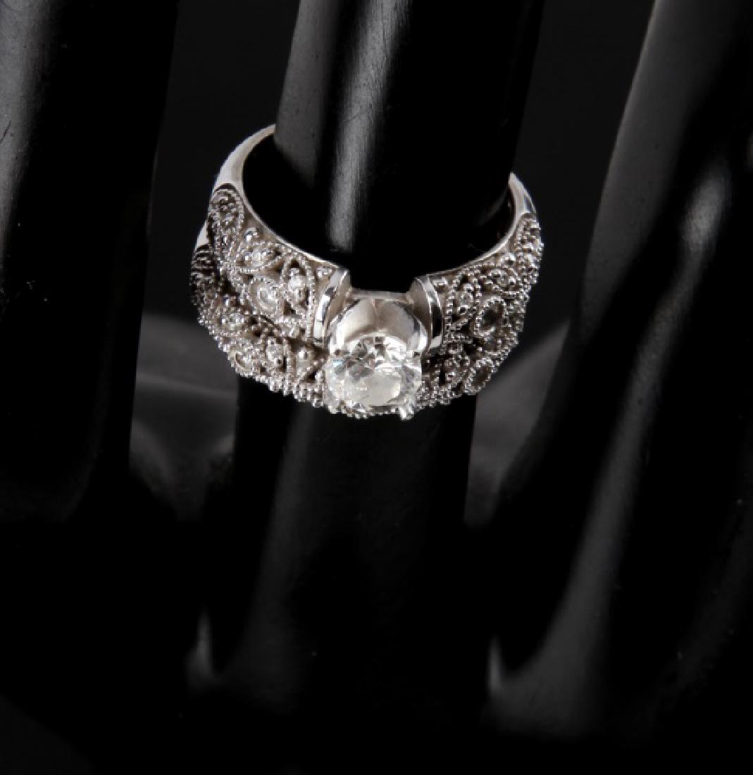14KT WHITE GOLD DIAMOND RING WEDDING SET .75 TCW: Round center stone measures 5.3mm in diameter and 3.5mm in depth, with total carat weight of .60 with J color and SI1 clarity (large internal fracture in one quadrant). The surrounding stones measure 
