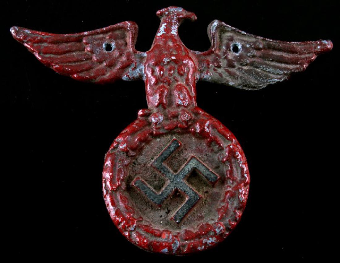 GERMAN WWII RED CAST IRON EAGLE WALL HANGER: German WWII red cast iron eagle insignia wall hanger. Fair paint wear. In good condition. Measures 6 3/4" tall and 8 3/4" wide.