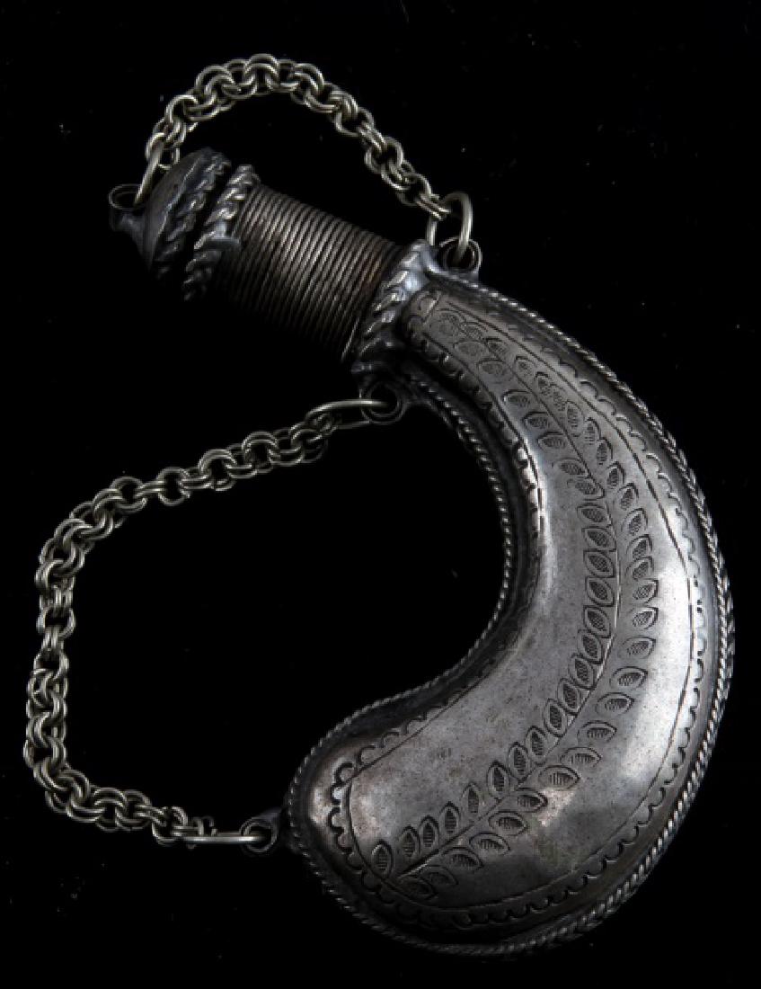 ANTIQUE SILVER POWDER FLASK CHAIN AND CAP: Powder flask made of silver, with the suspension chain and cap attached. Ornate and engraved design with different designs on each side. Measures 4 1/2 inches in length and weighs 82.3 grams. In good 