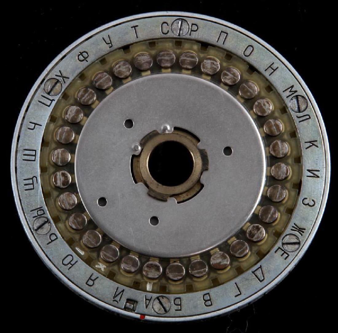 COLD WAR ERA SOVIET RUSSIAN ROTOR CIPHER MACHINE: Cold War era USSR Soviet Russian rotor cipher machine, measuring 2.5'' in diameter with circumscribed Russian alphabetical characters. Rotor cipher machine appears to also be circumscribed on the oute
