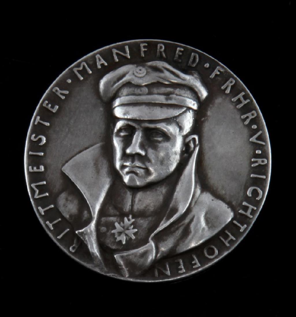 ART MEDALLION WWI GERMAN RED BARON VON RICHTHOFEN: Around the edge says "Der Rote Kampfflieger" ( The Red War Flyer) Under is the number 80 for his 80 confirmed air combat wins. Also is the date April 21 1918 the date of the Red Barons death. This lot