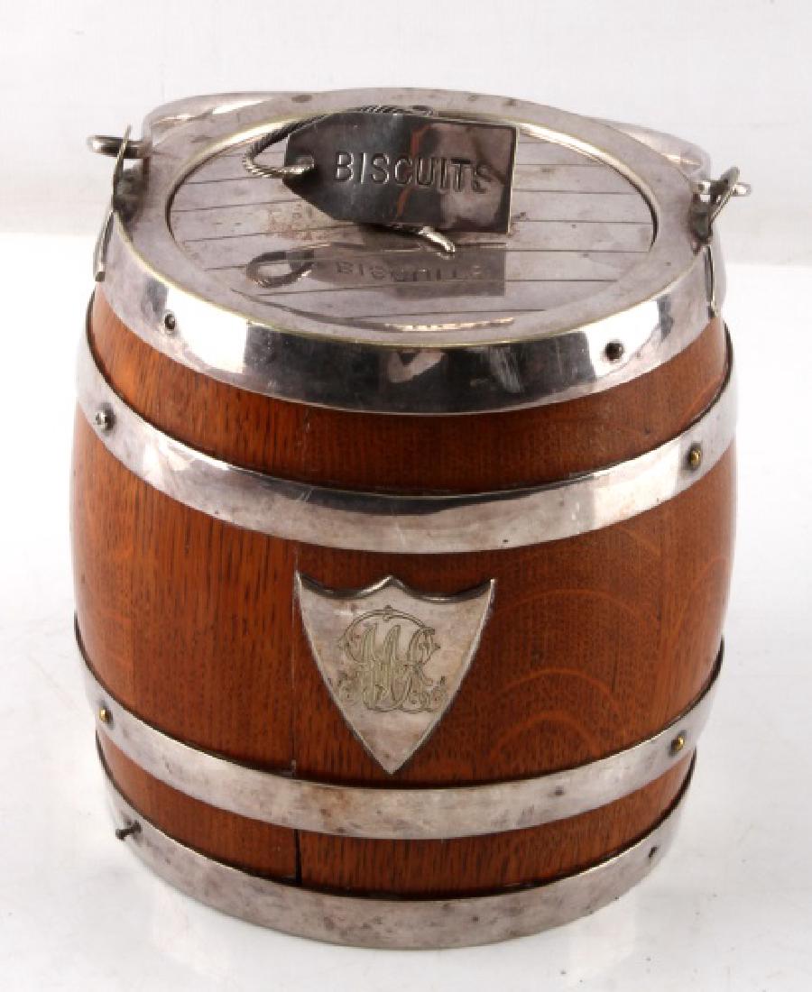 VINTAGE SILVER & OAK BISCUIT BARREL: Vintage oak and porcelain "biscuits" barrel with silver accents (silver has been tested) and some engraving to front silver piece. Inside of barrel has some crazing and outside has some split to wood