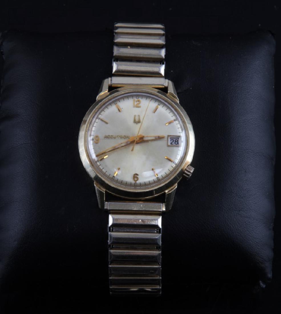 VINTAGE MENS BULOVA ACCUTRON GOLD FILLED WATCH: 14KT gold filled case, maker marked and serial number J144555 with NI below to back. Date peep hole at 3 o'clock, numbers at 12, 6, and 9. Speidel USA stretchable band. Face measures 29mm. Minor wear,
