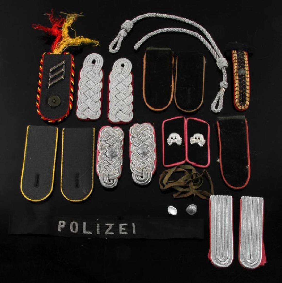 LOT GERMAN WWII SHOULDER BOARDS HAT CORD & POLIZEI: Shoulder board/collar tab lot includes three (3) pair of Panzer collar insignia replicas, two (2) other pair, and five (5) single boards. Also includes some silver hat cord and a Polizei arm band.