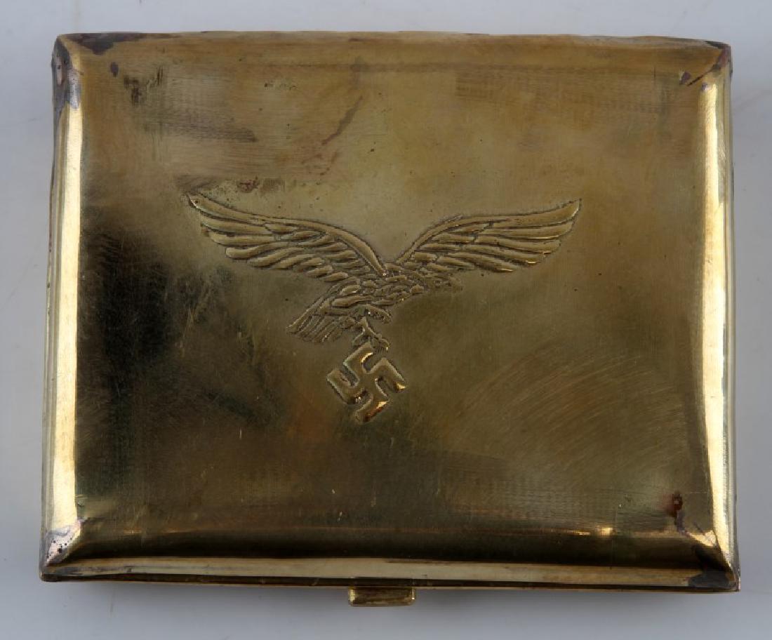 WWII GERMAN LUFTWAFFE PILOT CIGARETTE CASE: Some wear and small dents present. One elastic strap inside. Case opens to roughly a 90 degree angle and appears to be slightly bent. Measures approx. 4 1/4" x 3 1/2". Unauthenticated. Sold "as is". T