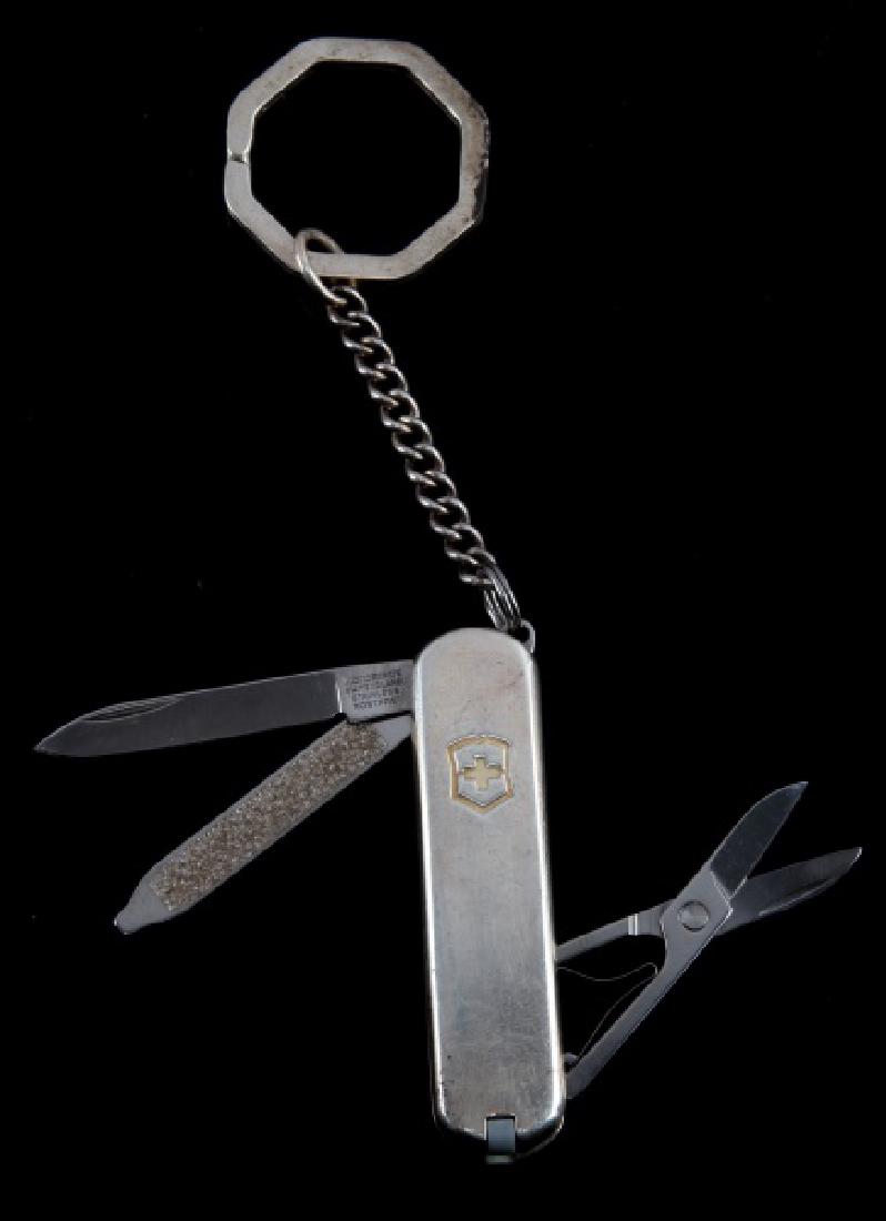TIFFANY & CO. STERLING AND 18KT SWISS POCKET KNIFE: Sterling silver with gold inlay to swiss cross logo. Marked to knife "Victorinox Switzerland Stainless Rostfrei." Marked to back "Tiffany & Co. 925 750." Comes with knife, nail file, scissors, toothpi