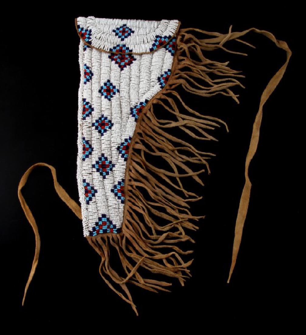 AUTHENTIC SIOUX INDIAN LEATHER BEADED GUN HOLSTER: Vintage left side 12 inch Sioux beaded leather, appears to be brain tanned, with fringe is in good condition. Traditional beadwork pattern is completely intact.