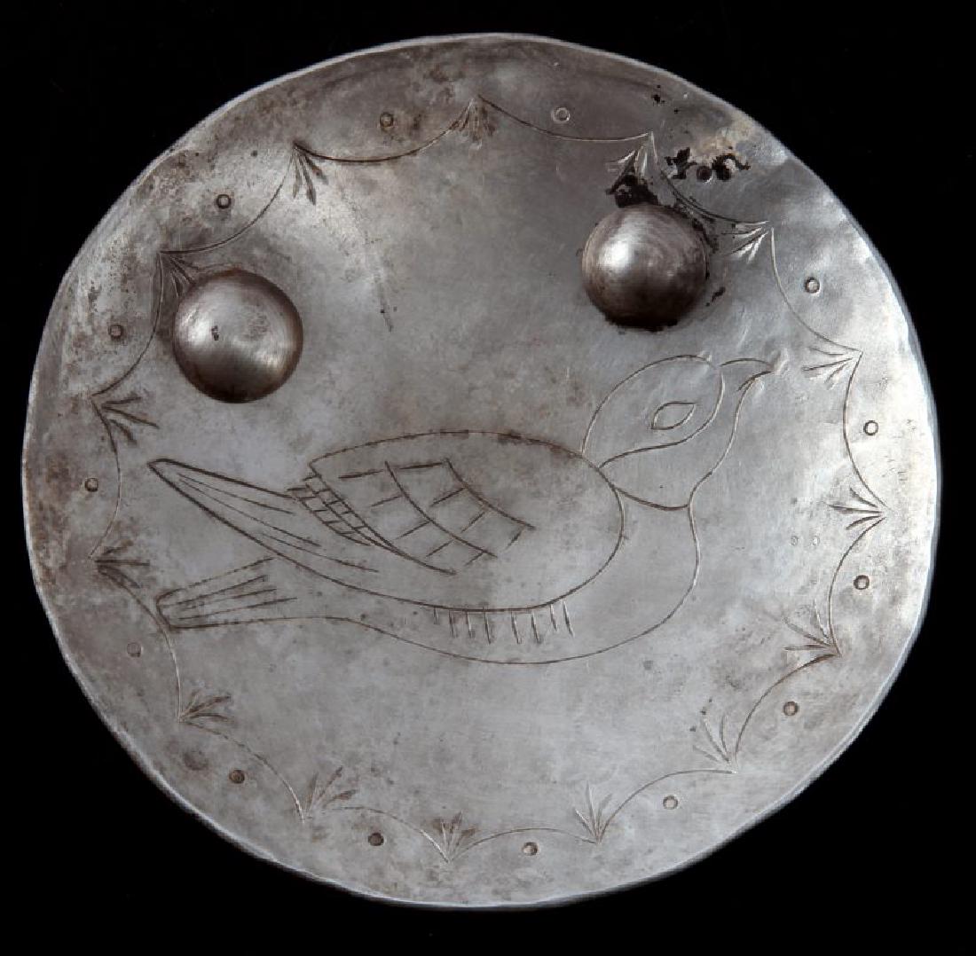 NATIVE AMERICAN ANTIQUE FUR TRADE SILVER PENDANT: Round silver fur trade pendant. Has an image of a bird engraved in the front. No other identifiable hallmarks. Measures 8 cm in diameter, and has two rivets, though the studs have broken off the back
