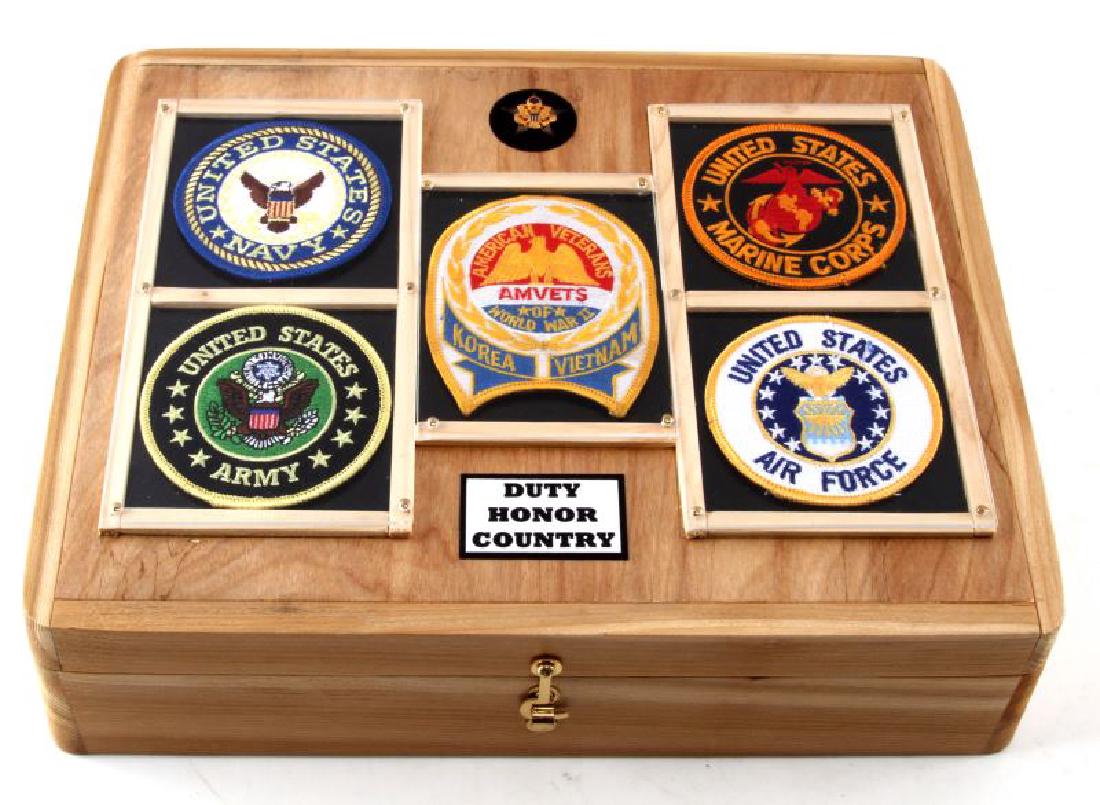 MILITARY EMBLEM & DUTY INSIGNIA DECORATED WOODBOX: Large emblem rank & duty insignia decorated wooden military box from Tallahassee artist Randy J Smith 's Duty Honor & Country Collection, interior of box is lined with American flag upholstery and is 