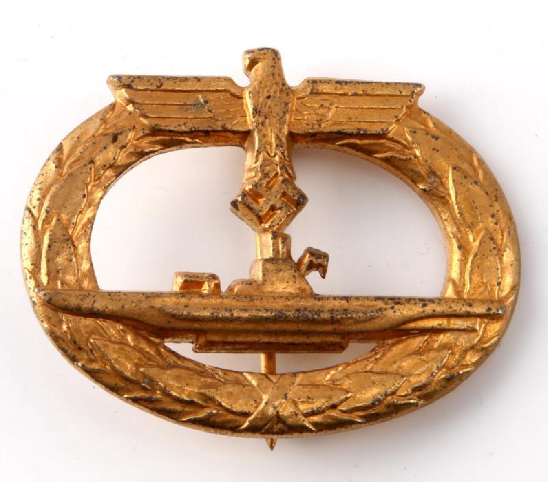 WWII GERMAN NAVAL KREIGSMARINE U BOAT SUB BADGE: Front shows the profile of a submarine in the center with a German eagle above. Both are surrounded by an oval oak leaf wreath. Reverse side is marked 'GWL'. Has a thin vertical pin back with a 180 de